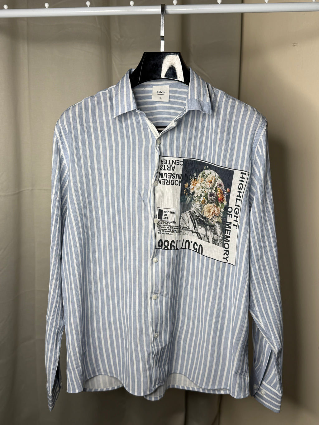 Blue and white striped shirt with a graphic patch