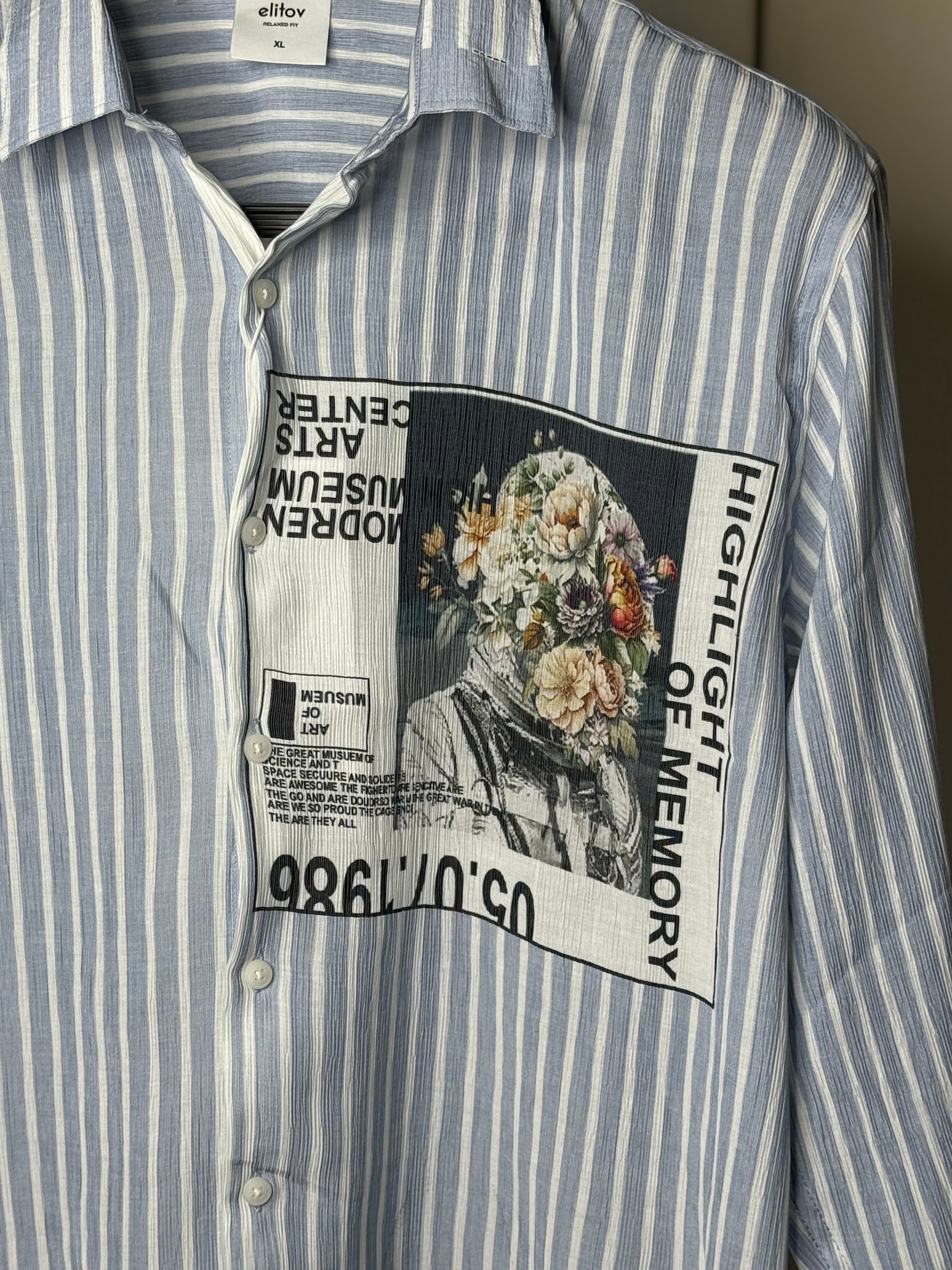 Blue and white striped shirt with a graphic patch