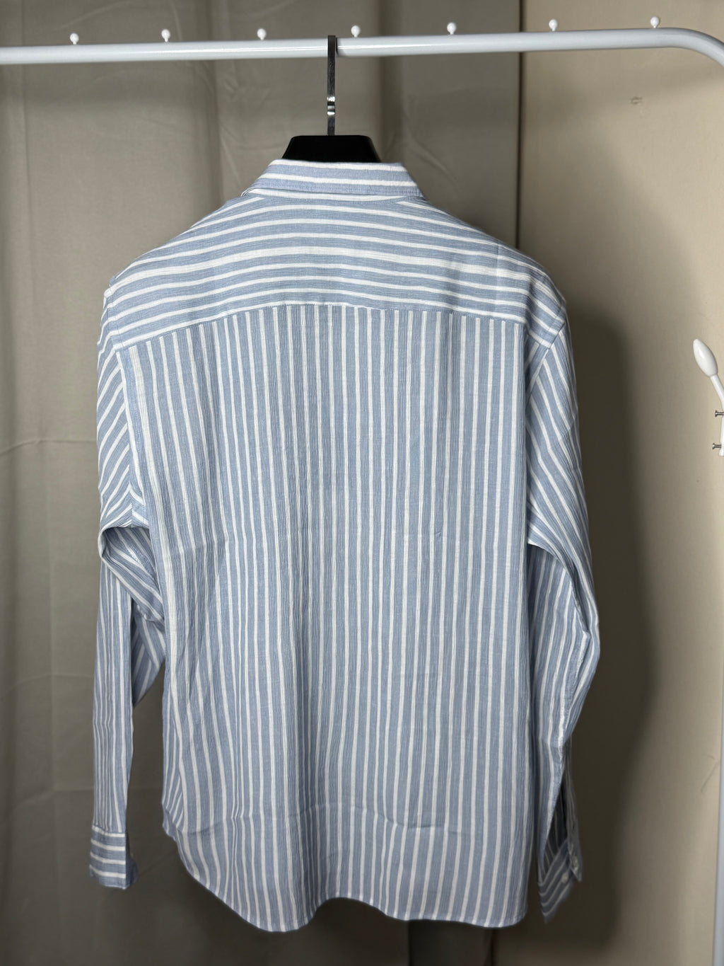 Blue and white striped shirt with a graphic patch