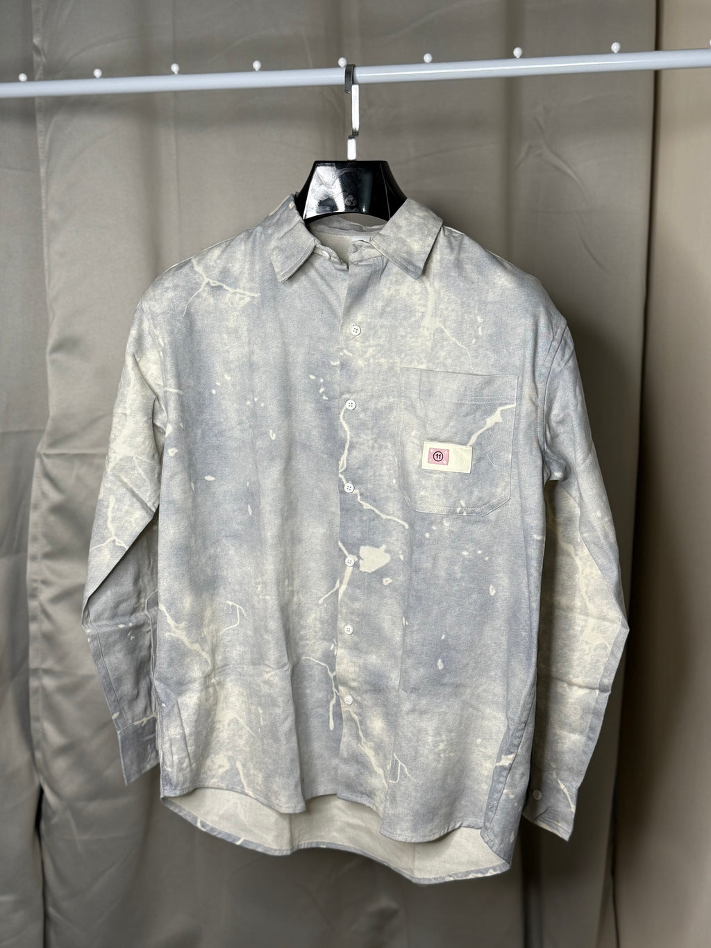 This shirt features a paint-splatter or tie-dye design