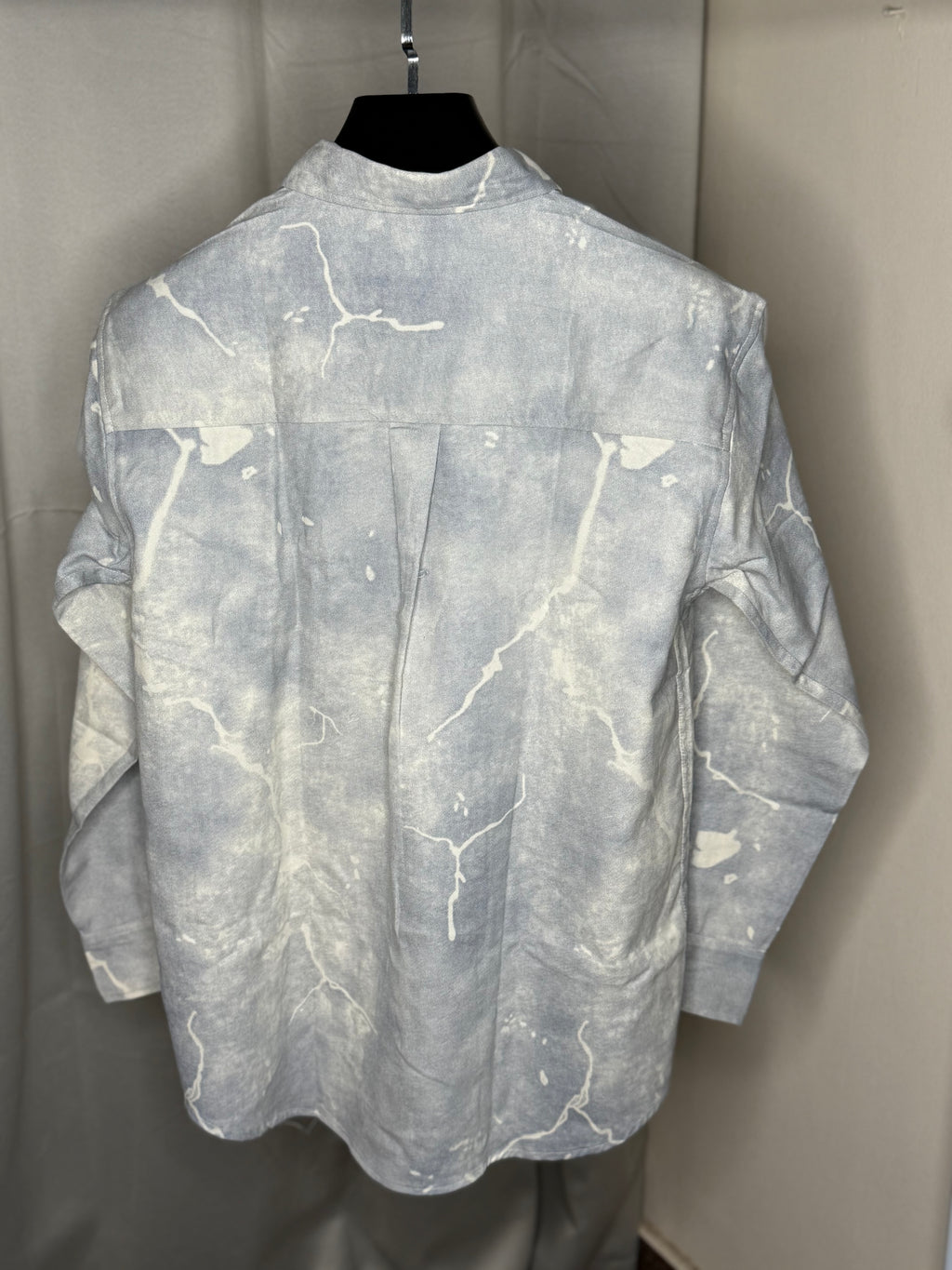 This shirt features a paint-splatter or tie-dye design